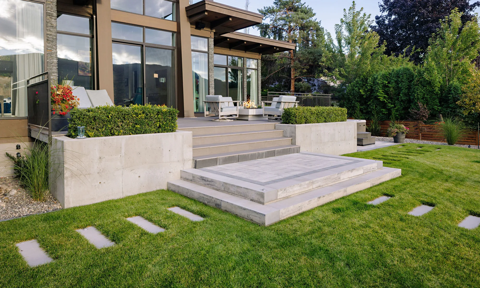 modern home and retaining wall and shrubs and trees