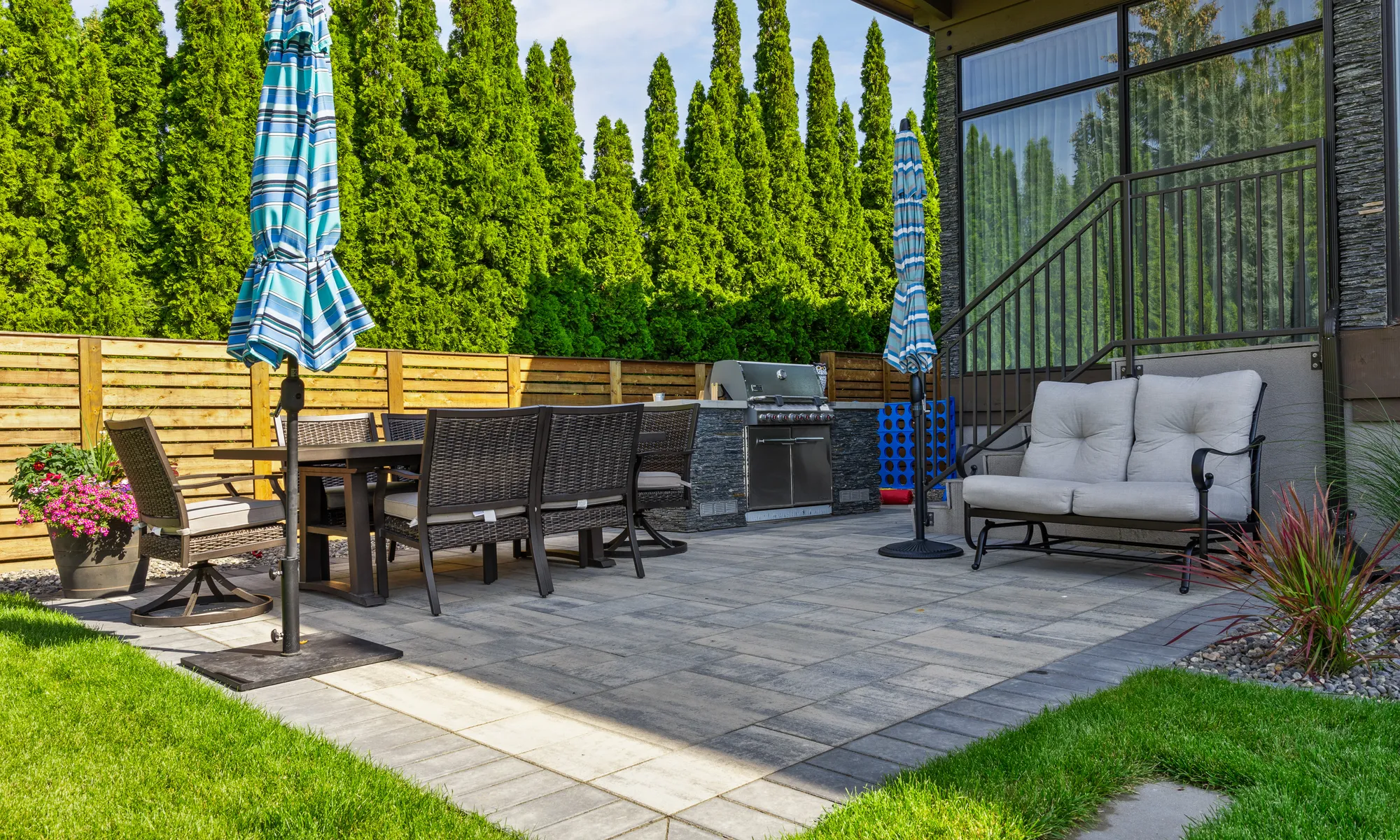 stone patio and bbq and green hedges