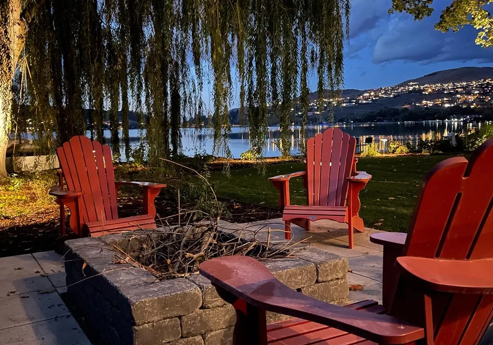 fire place with red chairs lake front
