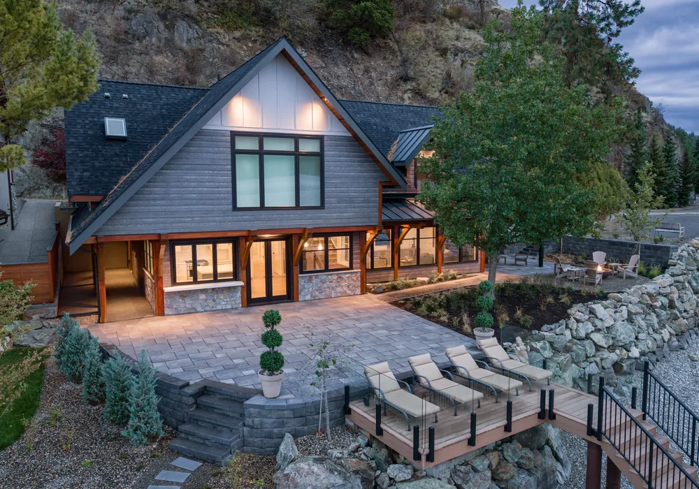 lake front home with stairs and shrubs