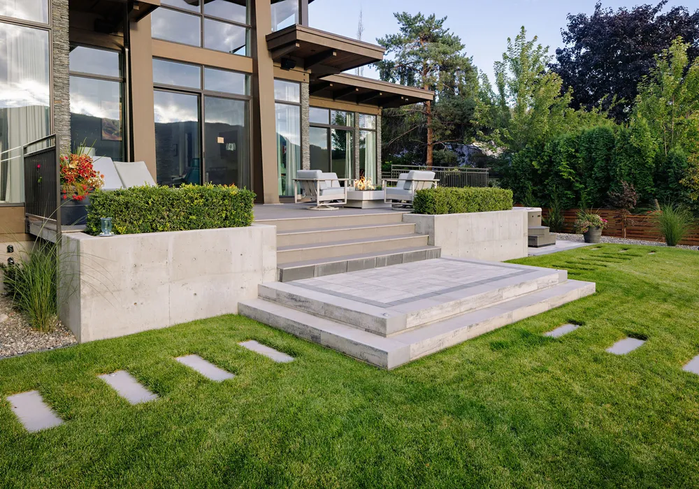 modern home and retaining wall and shrubs and trees