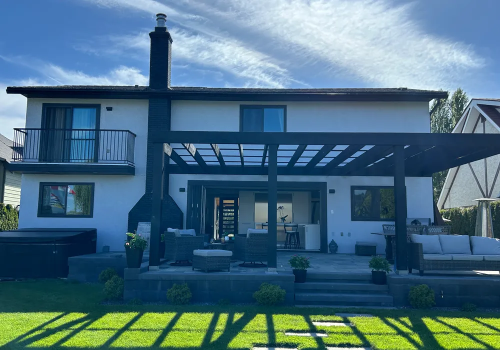 patio and pragola with shrubs and wall of stone