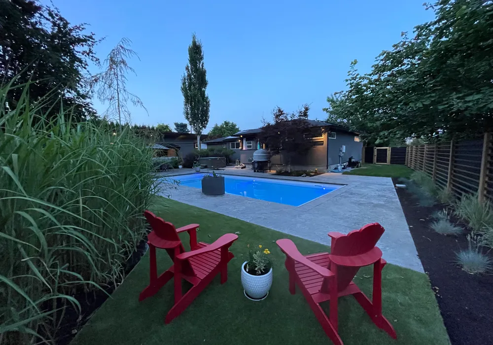 pool with red chairs and grass