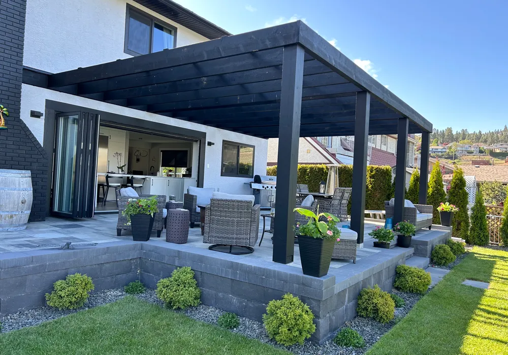 pragola with shrubs and patio and wall of stone