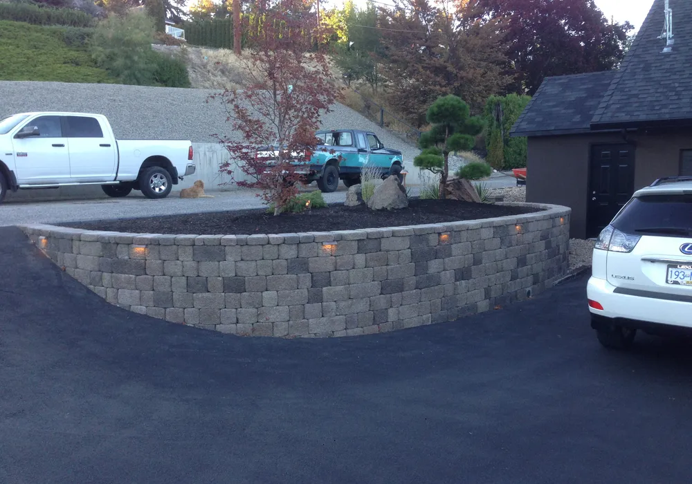 retaining wall with tree and two trucks in the background