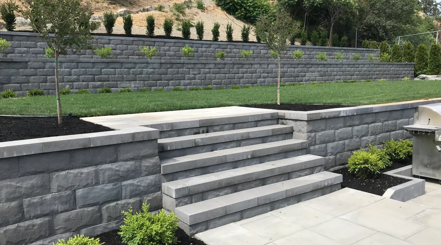 paver stone flooring green yard and retaining wall