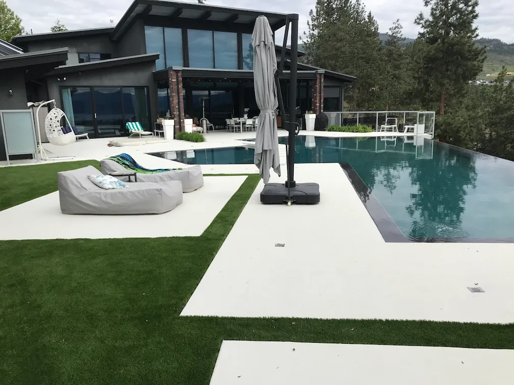 Artificial turf and a view of a modern home and a pool